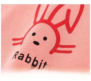 Detail of pink cotton girl's T-shirt showing cartoon rabbit print and knit texture