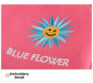 Close-up of blue sunflower embroidery with BLUE FLOWER text on pink girls' pants