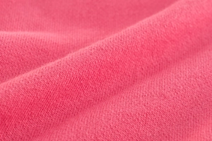 Close-up of watermelon red jersey knit fabric texture for girls sports trousers
