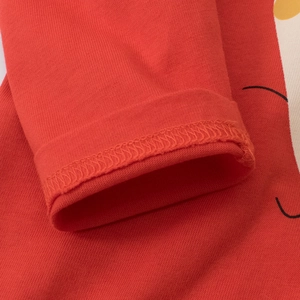 Close-up of red long sleeve cotton T-shirt showing detailed overlock stitching and knit texture