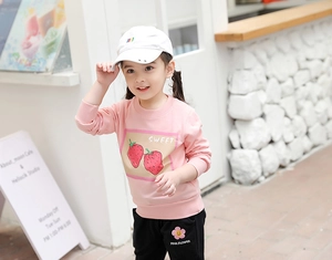 Détail du sweat à fraise rose et de l'ensemble de pantalon noir pour petites filles