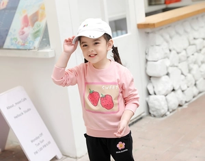 Détail de l'ensemble sweat rose avec fraises et pantalon noir à fleurs pour filles