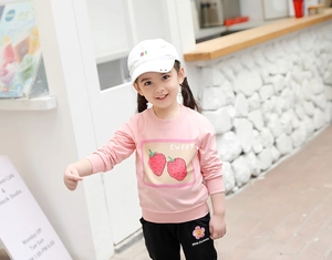 Détail du sweat-shirt en coton rose avec imprimé fraise et pantalon noir pour petites filles