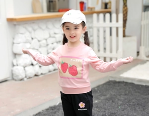 Détail du sweat-shirt rose à fraises et du pantalon de jogging noir fleuri pour fille