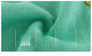 Detail showing soft mint green knit texture and matching button of A-grade baby cardigan