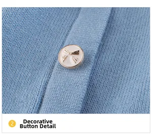 Detail showing soft light blue knit texture and decorative golden bow button on cardigan