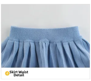 Detail view of the ribbed elastic waistband and pleats on girls' light blue knit skirt