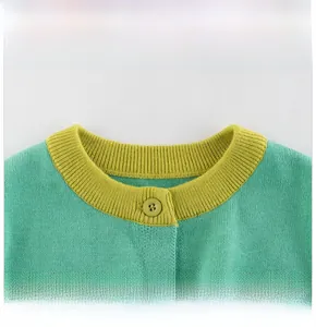 Detail of baby knit cardigan showing yellow ribbed neckline and green knit texture