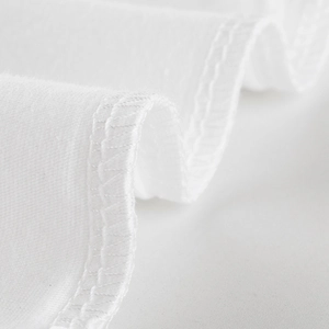 Detailed macro view of white cotton fabric with professional double-needle stitching on cuff