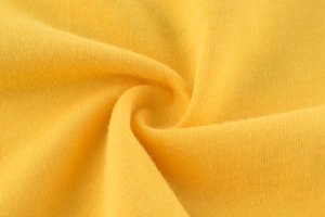 Primer plano de suave tejido de punto de algodón amarillo con textura para camisetas de niños