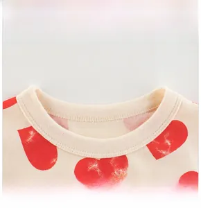 Détail de l'encolure d'un t-shirt enfant en coton crème à motifs de cœurs