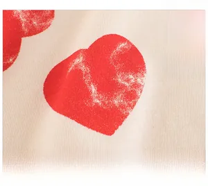 Gros plan du motif de cœur sur t-shirt enfant montrant la texture et l'imprimé rouge
