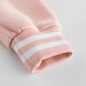 Pink girl's fleece joggers featuring sporty ribbed cuffs with classic white stripes