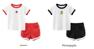 Dettaglio del ricamo di fragola e ananas sui completi estivi in cotone per bambini