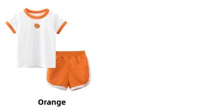 Dettaglio della maglietta bianca con bordo arancione e pantaloncini abbinati da bambina
