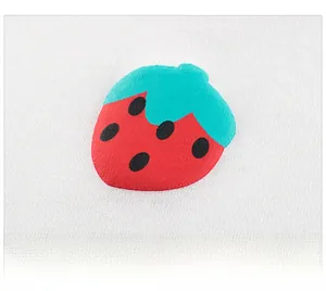 Dettaglio della stampa a fragola su morbido tessuto di cotone bianco per bimbi