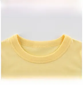 Détail de l'encolure d'un t-shirt jaune en coton avec une finition côtelée de qualité