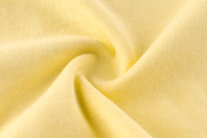Vue macro détaillée du tissu en coton tricoté jaune pâle doux pour t-shirt enfant