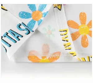 Détail de l'ourlet du t-shirt blanc en coton avec imprimé soleil et texte fantasy