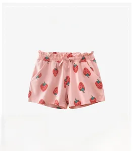 Detail of pink cotton girl's shorts featuring strawberry print and bow elastic waistband