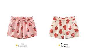 Detailed view of kids summer shorts with strawberry and heart prints and bow waistbands