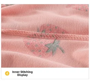 Detailed close-up of neat overlock stitching and strawberry print on knit fabric