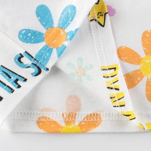 Gros plan d'un t-shirt en coton pour fille avec imprimé fleuri et détails de l'ourlet