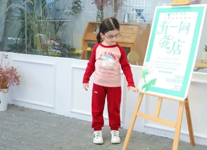 Detail of girls pink raglan sleeve T-shirt and matching red joggers with rabbit print