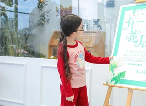 Detail of pink and red long-sleeve cotton shirt with cute cartoon rabbit print for girls
