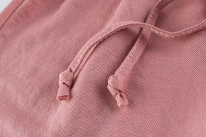 Macro shot of dusty pink knitted fabric with matching braided drawstring for kids pants