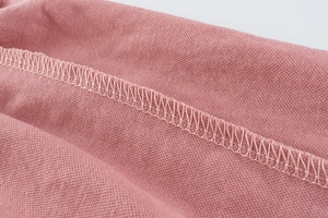 Detailed macro view of pink breathable cotton fabric with professional double stitching