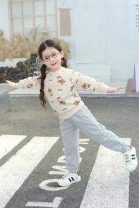 Outdoor shot of girls beige bear print sweatshirt and grey joggers casual outfit set