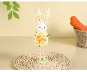 Detail of Easter bunny ornament with yellow flower, plaid ears and pink shoes on green base