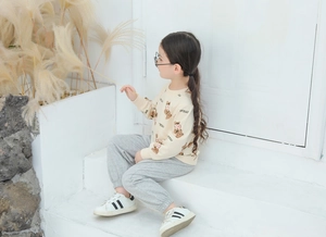 Kids casual sweat suit featuring teddy bear print sweatshirt and grey joggers on a model