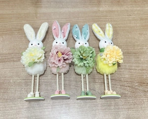 Close-up of four Easter bunny figurines with long legs and large colorful fabric flowers