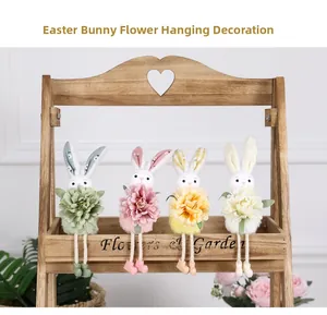 Dettaglio di quattro peluche coniglietti pasquali colorati con fiori su supporto in legno