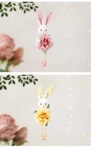 Detail of plush Easter bunny hanging ornaments holding silk flowers in pink and yellow