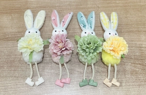 Detail of four colorful Easter bunny plush pendants with large flowers and embroidered faces