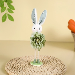 Standing Easter bunny plush decor holding green flower on woven mat with carrots