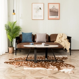 Modern oval coffee table with white marble top and black metal legs in cozy living room