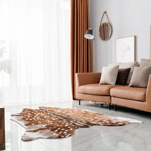 Faux deer hide rug with white spots on marble floor in a cozy living room decor