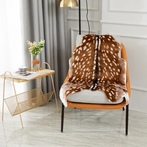 Detail of faux sika deer fur rug with white spots draped over a modern grey lounge chair