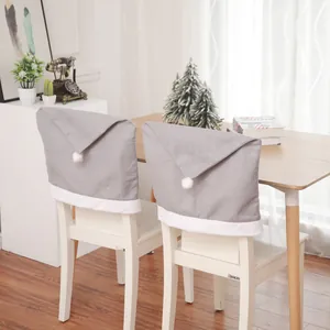 Detail of gray non-woven Christmas hat chair covers with white plush trim for dining chairs