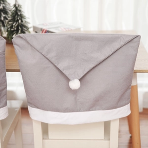 Close-up of grey and white Christmas chair back cover with festive pom-pom hat design