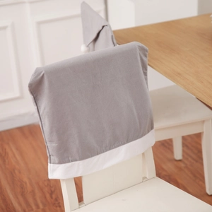 Close-up of grey Christmas hat chair cover with white border in a dining room setting