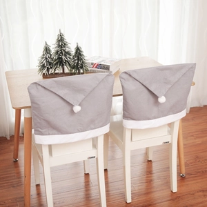 Pair of gray Santa hat chair covers with white plush pom-poms for festive dining decor