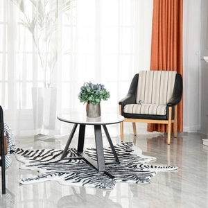 Close-up of zebra pattern irregular rug under a modern white round coffee table