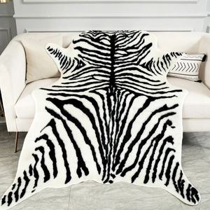Faux zebra print area rug with irregular edges draped over a modern sofa and floor