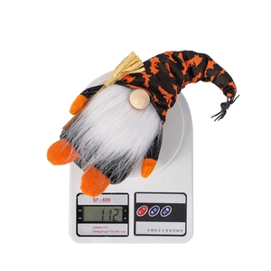 Close-up of a Halloween gnome on a digital scale showing its light weight of 112 grams