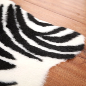 Detailopname van de zebra-textuur van imitatiebont op een warme bruine houten vloer